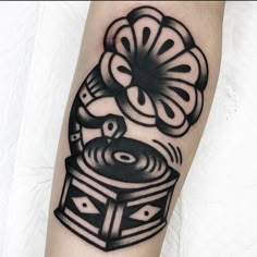 a black and white tattoo on the leg of a person with an old record player