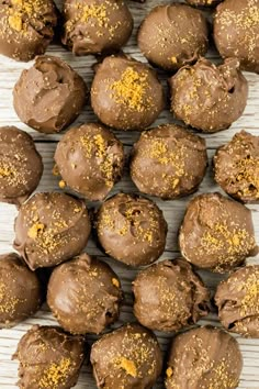 chocolate truffles with golden sprinkles are on a white surface