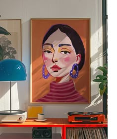 a painting is hanging on the wall next to a table with records and a lamp