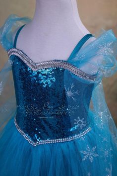 the dress is blue and has snowflakes on it