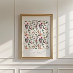 an art print hangs on the wall next to a white fireplace with a gold frame