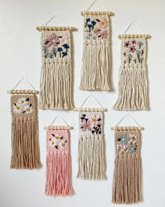 four wall hangings with flowers on them