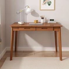 a wooden desk with two drawers and a lamp on top of it in a room