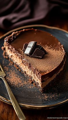 a piece of chocolate cake on a plate with a knife and fork next to it