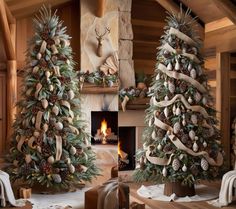 two christmas trees decorated with pine cones and ribbons in front of a fireplace, surrounded by other holiday decorations