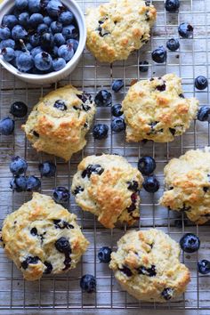 blueberry muffins cooling on a wire rack next to a bowl of blueberries