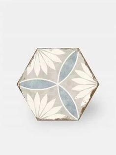 a white and blue flower design on the side of a small bowl with leaves in it