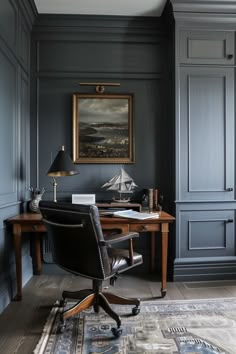 a home office with dark blue walls and leather chair in front of a wooden desk