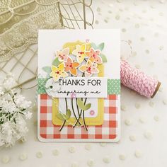 a close up of a card with flowers on it and a spool of thread