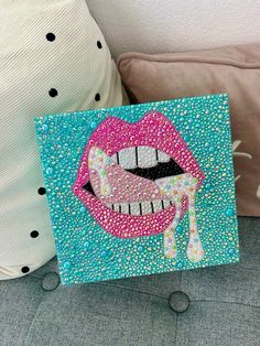 a pillow with a painting of a mouth and tongue on it next to a cushion