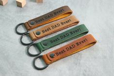 four leather keychains with the words best dad ever on them, sitting next to each other