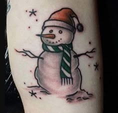 a snowman with a hat and scarf on it's arm is shown in this tattoo