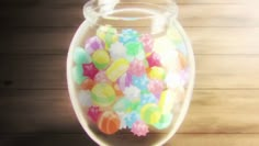 a glass jar filled with candy on top of a wooden table