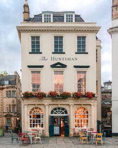 the huntsman hotel is located in an old town square with tables and chairs outside