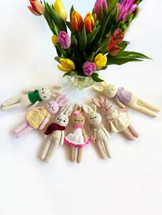 a vase filled with lots of colorful tulips next to stuffed animals and flowers