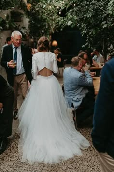 the back of a bride's dress as she walks down the aisle with her father