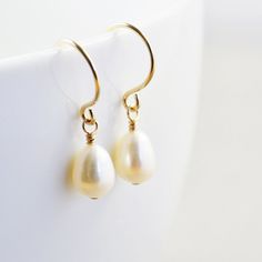 "White pearl earrings. Gold filled earrings featuring lustrous 7mm white freshwater teardrop shaped pearls handpicked to match as perfect as possible. They hang from handcrafted gold filled ear wires I created especially for these pearls. Perfect for everyday wear! Length from top of ear wire is slightly under 1\". Variations: Sterling silver Gold fill Rose gold fill Complimentary Gift Wrap! Not quite what you are looking for? Other earrings available: Studs: http://etsy.me/1zWKO9Q Earrings: htt Pear-shaped Pearl Charm Earrings For Anniversary, Pear-shaped Pearl Pendant Earrings For Gifts, Pearl Charm Pear-shaped Earrings For Gift, Classic Pearl Teardrop Earrings, Pear-shaped Pearl Charm Earrings For Gift, Hypoallergenic Drop Pearl Earrings For Gift, Classic Teardrop Pearl Earrings With Pearl Pendant, Classic Pearl Teardrop Dangle Earrings, Classic Pearl White Teardrop (pear Shaped) Earrings