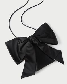 Evening crossbody bag in black satin with an oversized bow. Features a magnetic closure and lined interior. Chic Party Bag With Ribbon Detail, Chic Party Bag With Ribbon, Evening Bags With Bow Detail, Elegant Black Bag With Bow, Black Formal Bag With Bow, Formal Black Bag With Bow, Black Party Bags With Bow Detail, Black Bag With Detachable Bow, Chic Formal Bags With Satin Bow