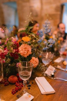 a wooden table topped with glasses and flowers