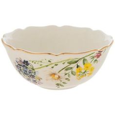 a white bowl with yellow and blue flowers on the rim, in front of a white background