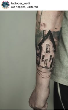 a man with a house tattoo on his arm