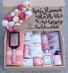 an open box with pink and white flowers on the floor next to some personal care products