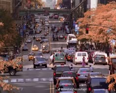 a busy city street filled with lots of traffic next to tall buildings on either side of the road