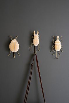 three wall mounted lamps on the side of a gray wall next to an old pair of scissors