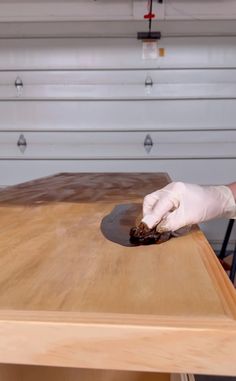 a person in white gloves is cutting wood