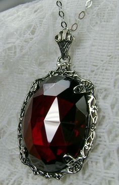 "Red Garnet Cubic Zirconia Pendant Bubble Design#P10 Custom Made Inspired by Victorian era designs, I now offer this lovely Antique reproduction in sterling silver. The flawless 22ct faceted Red Garnet Cubic Zirconia (CZ) is 24mm long (15/16th\") and 18mm in width (3/4th\"). The entire pendant is 1 1/2th inches long and 7/8\" wide. The chain (if chosen) is between 18-20 inches in length and is marked 925 as well. Notice the beautiful craftsmanship of the Victorian filigree setting. This pendant