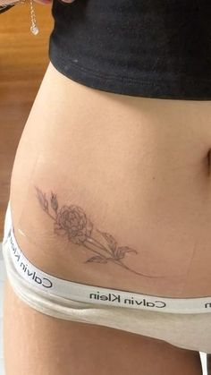 a close up of a person's stomach with flowers on it and the words calvin kisin written below