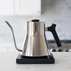 a stainless steel coffee pot sitting on top of a counter