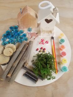 a white plate topped with lots of crafting supplies on top of a wooden table