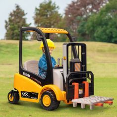 a young boy driving a forklift in the grass