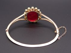 Jewelry Type: Bracelet Metal: 14k Yellow Gold Measurements: Length: 7 inch Top: 30mm x 25mm Markings: None ( scratch & acid tested) Weight: 17.2 grams Center: Oval Cut Venetian Glass w carved Intaglio Color: Red Measurements: 23mm x 18mm Accent Stones: 8 matching Rose Cut Diamonds Color: H Clarity: SI-1 Weight: 0.40cts total approx Accent Stones: 8 matching Round Pearls Color: White Measurements: 2.5mm #12219 Diamond Intaglio Jewelry, Round Diamond Intaglio Jewelry, Formal Yellow Gold Bangle With Rose Cut Diamonds, Yellow Gold Cabochon Bracelets For Weddings, Gold Intaglio Jewelry For Evening, Formal Intaglio Bangle Jewelry, Formal Rose Cut Diamond Bangle, Evening Diamond Bracelet, Pearl Bangle