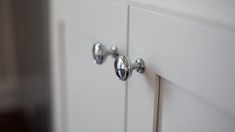 two knobs on the front of a white cabinet