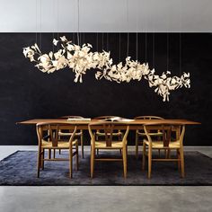 a dining room table with chairs and a chandelier hanging from it's ceiling