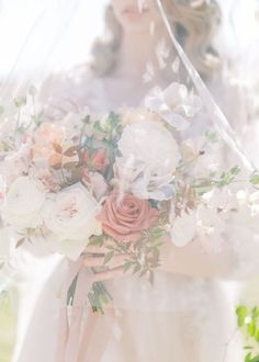 a bride holding a bouquet of flowers in her hands