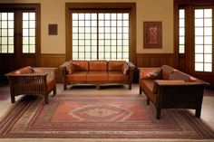 a living room filled with brown furniture and lots of wood trimming on the walls