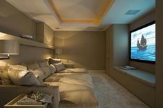 a living room filled with lots of furniture and a flat screen tv mounted to the wall