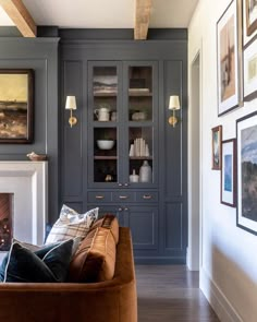 a living room filled with furniture next to a fire place and pictures on the wall