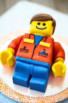 a lego man is sitting on top of a white and orange plate with an orange and blue jacket