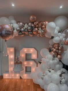 a room filled with balloons and white letters