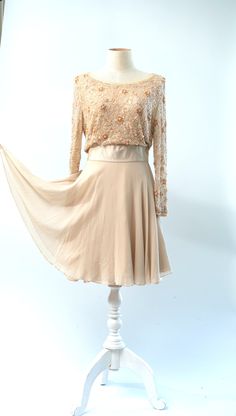 "Coolest dress...could be a wedding dress...or a guest of.. In a peach ivory with beautiful silkabsolutely stunning!! Excellent Beaded on tulle lined in silk Measuring: 36\" length Bust: 36\" Waist: 26\" Hip: 36\" + Sleeves: 22\" Pet Free/smoke free Enjoy!" Elegant Chiffon Mother Of The Bride Cocktail Dress, Elegant Cream Dress With Sheer Bodice, Cream Dress With Sheer Bodice For Evening, Cream Evening Dress For Wedding Guest, Embellished Flowy Evening Dresses, Elegant Sheer Cream Dress, Evening Flowy Embellished Dresses, Flowy Embellished Dresses For Evening, Flowy Embellished Evening Dresses