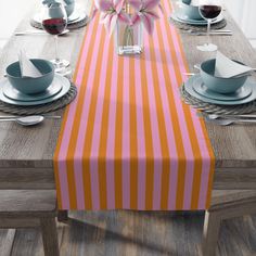 the table is set with plates, silverware and pink tulips in a vase