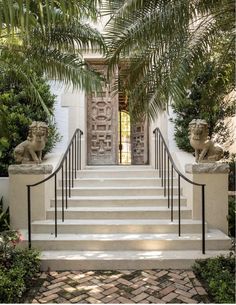 an entrance to a house with stairs and statues