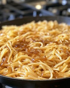 noodles are being cooked in a skillet on the stove