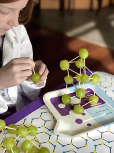 A budding scientist may create a skyscraper, molecule, or jungle gym with this fun food science activity! Grape molecules are great for a science party, mad scientist play date, or classroom. More Mad Science Party Ideas on HalfpintPartyDesign.com. #foodscience #kitchenscience #scienceactivity #kidscience #science Science Party Ideas, Vetenskapliga Experiment, Mad Scientist Halloween, Scientist Birthday Party, Mad Scientist Birthday