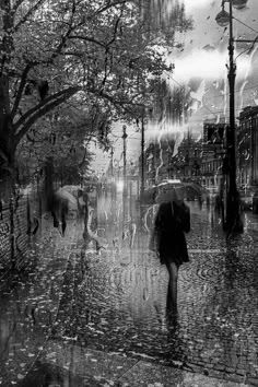 black and white photograph of people walking in the rain