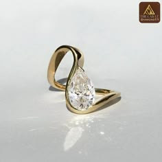 a gold ring with a pear shaped diamond